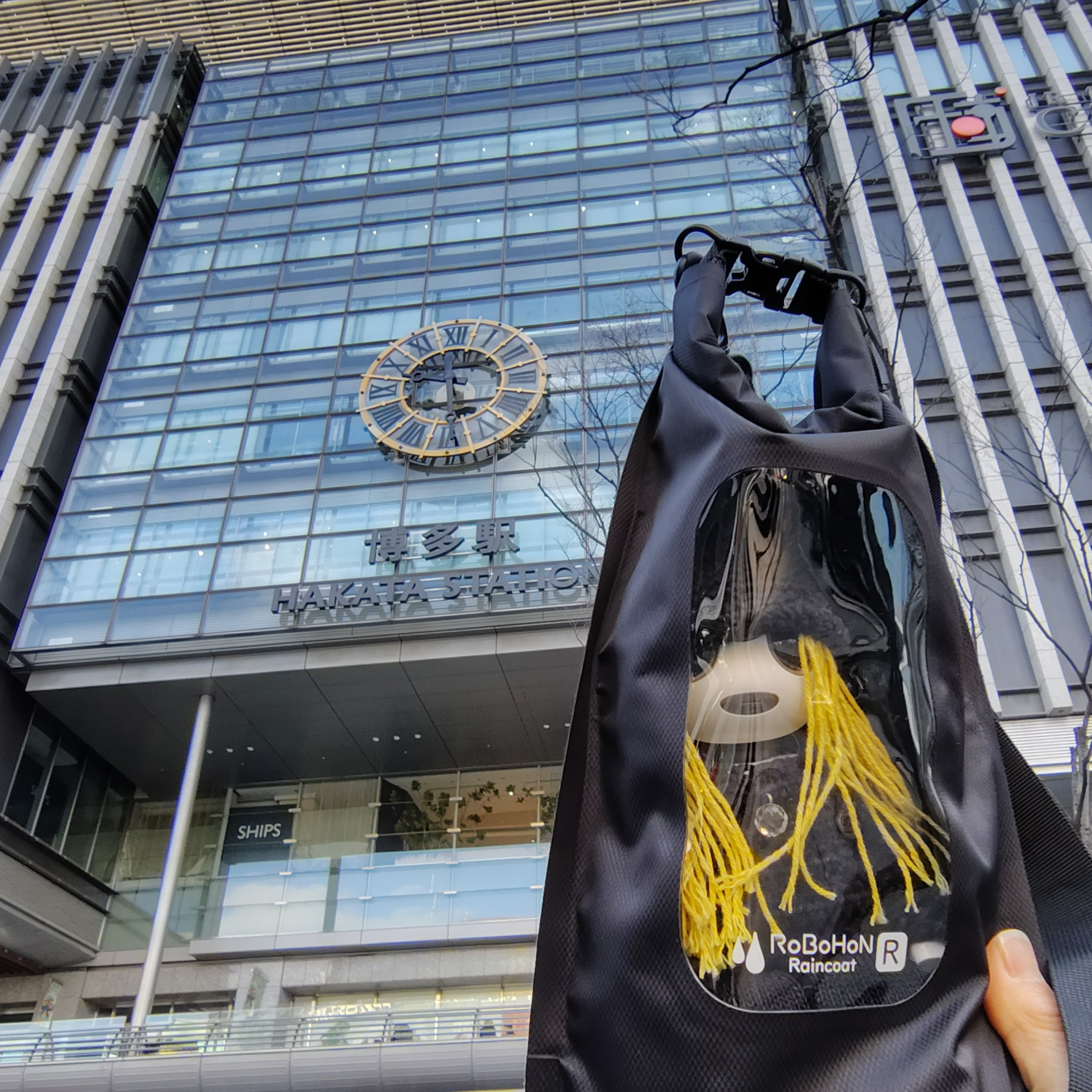 博多駅ビルを背景に記念撮影するぴーたー卿